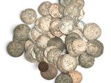 a pile of old coins on a white surface