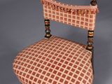 an antique chair with a checkered upholstered seat and wooden legs