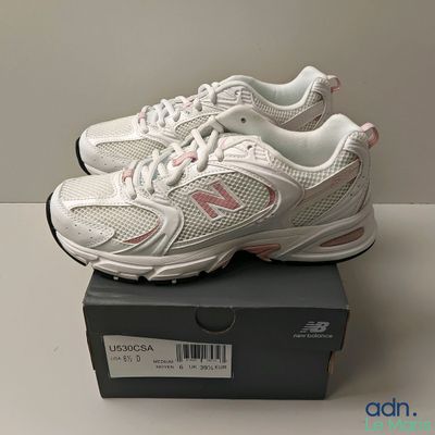 Les chaussures New Balance sont dans la boîte posée sur la table.