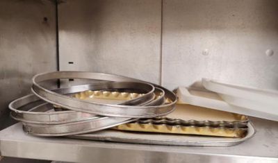 several pans of food are stacked on a shelf in a kitchen