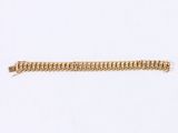 a close up of a gold bracelet on a white surface