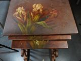 two tables with flowers painted on them sitting on a table