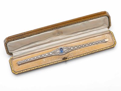 une montre dans un écrin posé sur une surface blanche