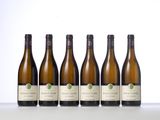 six bottles of white wine are lined up on a table