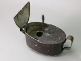 a small metal pot with a lid on a white surface
