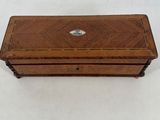 an old wooden box with a metal lid on a white surface