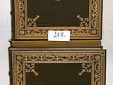pair of black and gold boxes with a lion emblem on the front