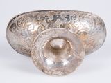 a silver bowl with a lid sitting on a table