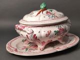 a white bowl with a bird on top of it on a plate