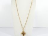 a gold necklace with a cross pendant on a mannequin neck