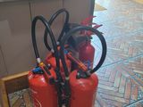 several fire extinguisors are lined up on the floor in a kitchen