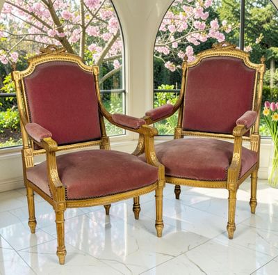 pair of red and gold chairs sitting in front of a large window