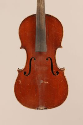 an old violin sitting on top of a white surface