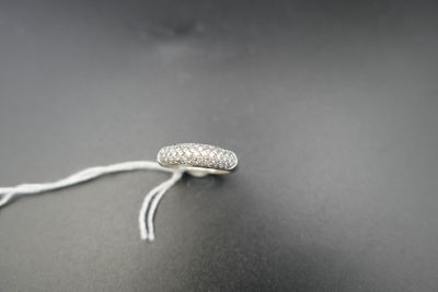 a close up of a silver bead on a string on a black surface