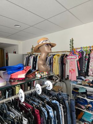 un présentoir de vêtements dans un magasin de mode, avec une tête de mannequin posée sur l'étagère