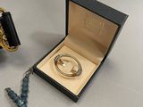 a necklace, bracelet, and ring in a box on a table