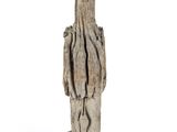 a wooden sculpture of a person standing on a white surface