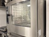 des fours en acier inoxydable dans une cuisine professionnelle, avec des casseroles et des poêles posées sur le plan de travail