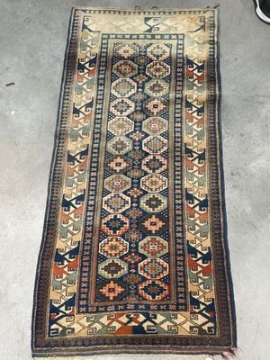 an old rug is laying on the floor next to a pair of shoes