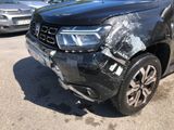a black car that has been damaged and is parked in a parking lot
