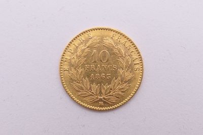 gros plan d'une pièce d'or sur une surface blanche