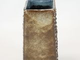 a brown and blue vase on a white surface