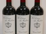 three bottles of red wine are lined up on a white surface
