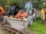 un bulldozer qui se trouve dans l'herbe, à côté d'autres engins de chantier