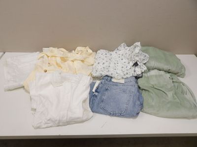 une table blanche recouverte d'une multitude de vêtements
