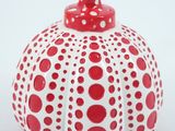 a red and white vase with polka dots on it