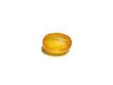 a close up of a yellow stone on a white surface