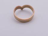 a close up of a heart shaped ring on a white surface