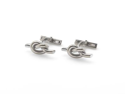 deux paires de boutons de manchette en argent sur fond blanc