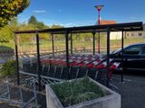 des voitures garées sur un parking à côté d'un caddie