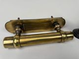 two antique brass toilet paper holders on a white surface