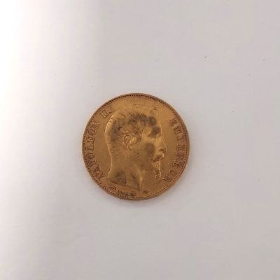 gros plan d'une pièce d'or sur une surface blanche