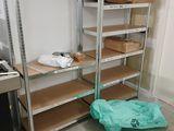 une étagère métallique sur laquelle sont posées de nombreuses boîtes, dans une pièce
