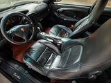 a car dashboard with a steering wheel and a leather seat