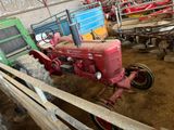 un tracteur qui se trouve dans une grange avec d'autres tracteurs