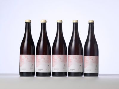 trois bouteilles de vin sont posées côte à côte sur une table