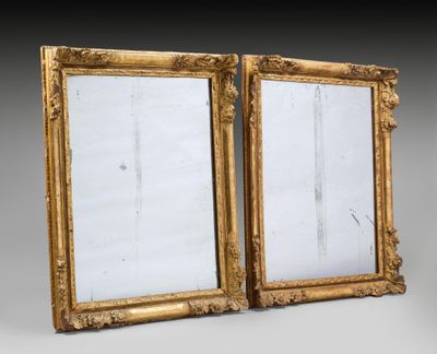 a pair of antique gold framed mirrors on a grey background