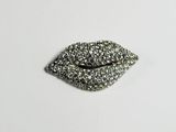a close up of a silver glittered lip on a white surface