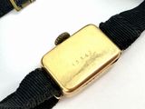 a gold watch on a black belt with a gold buckle