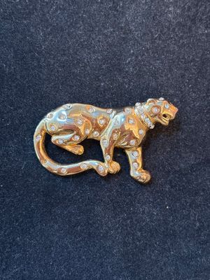 a close up of a brooch of a monkey on a black surface