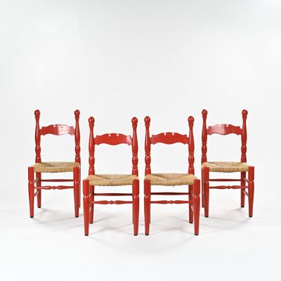 trois chaises rouges sont alignées devant un fond blanc