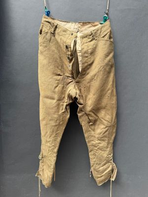 un vieux pantalon suspendu à une corde à linge fixée au mur