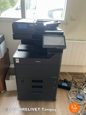 a printer that is sitting on the floor in front of a window