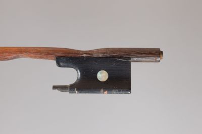 an old violin bow with a wooden handle on a white background