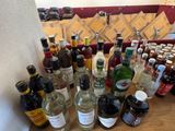 many bottles of alcohol sitting on a table next to each other