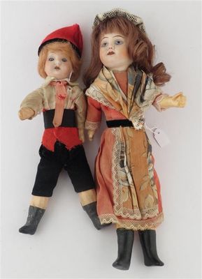 two dolls of a boy and a girl are standing next to each other